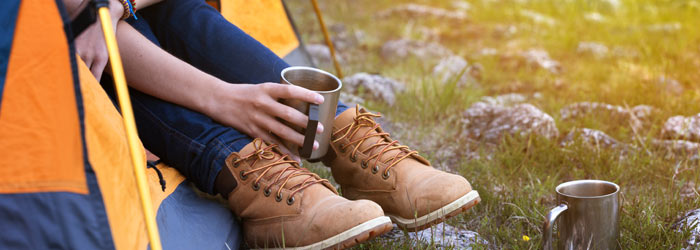 Camper enjoying a cup of tea in a tent (Shutterstock, Mostovyi Sergii Igorevich)
