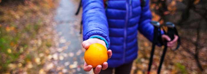 Camper holding orange (Shutterstock, By zhukovvvlad)
